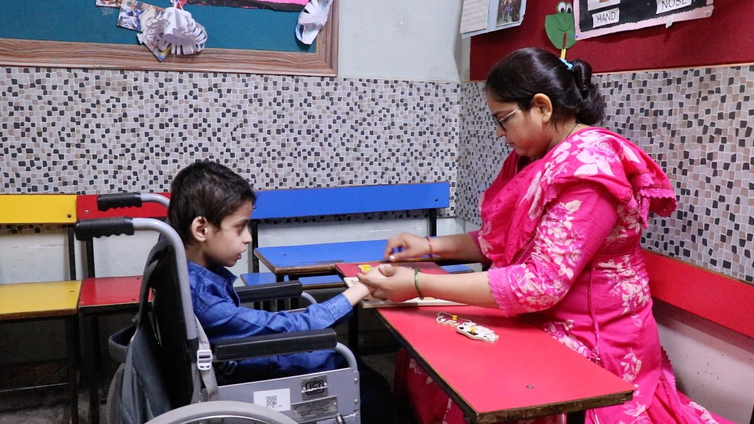 A special educator working with a child who uses a wheelchair